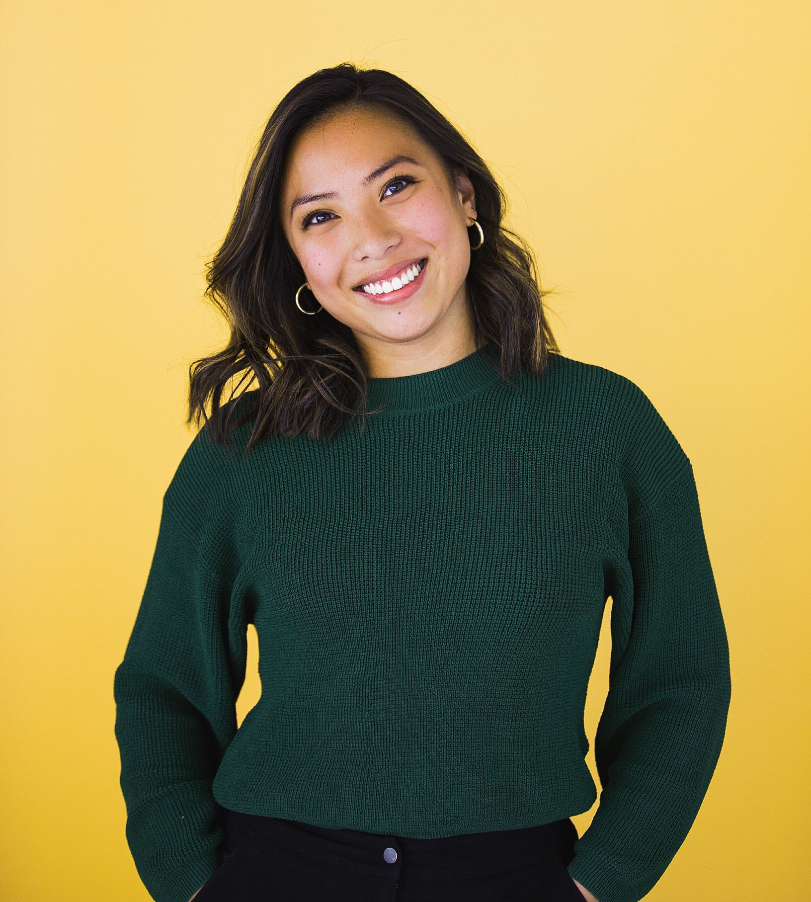 Nicole standing in front of a yellow background